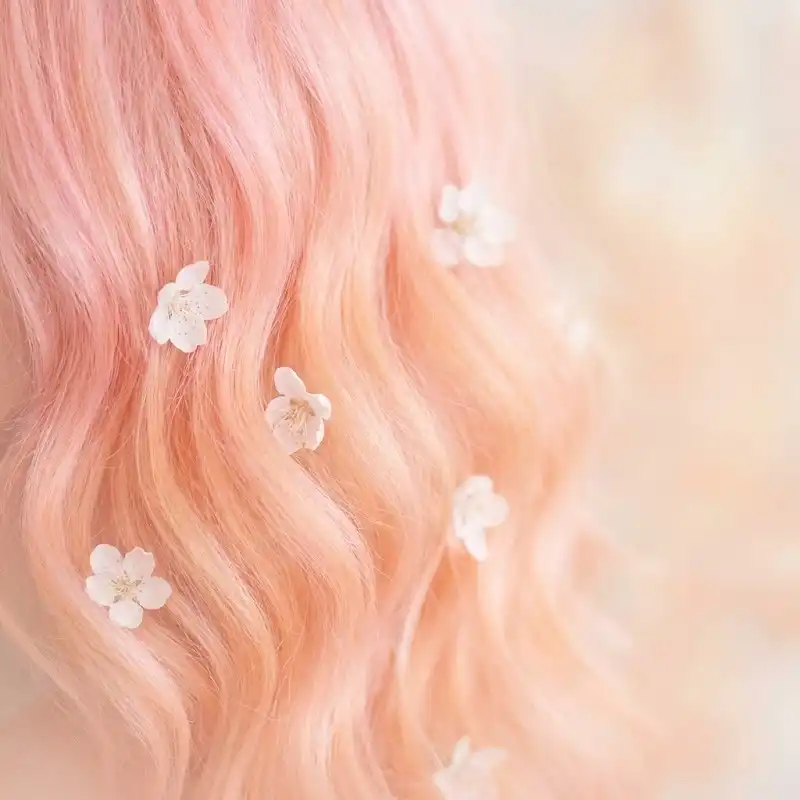 رنگ موی فانتزی و رویایی هلویی پاستلی (Peach Fuzz) تزئین شده با گل.